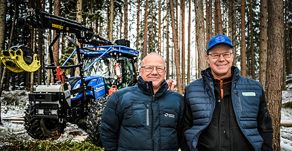 Två män framför Newholland-traktor