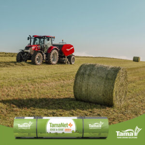 Röd traktor på fält med bal. Reklam tamanet